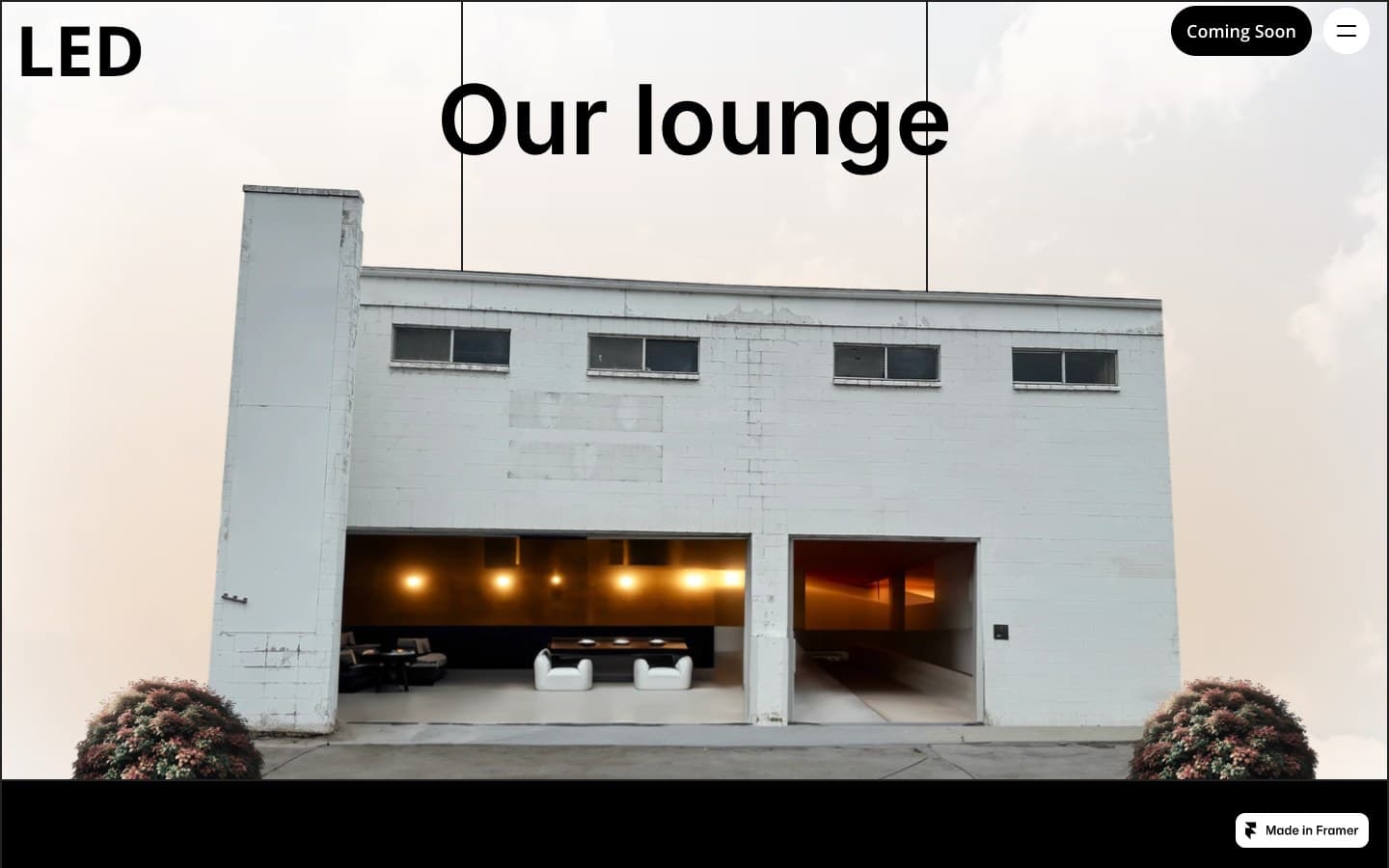 The same building with the lounge glowing warm through its open doors